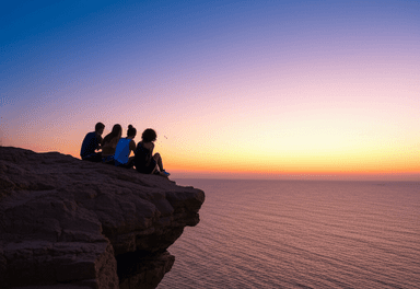 Friends enjoying sunset on cliff